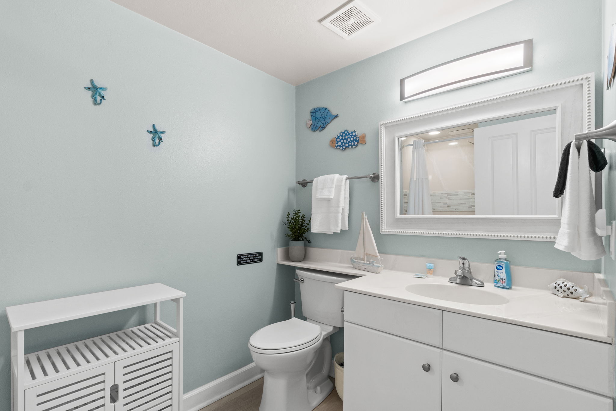 Bright coastal bathroom with spacious vanity and nautical decor