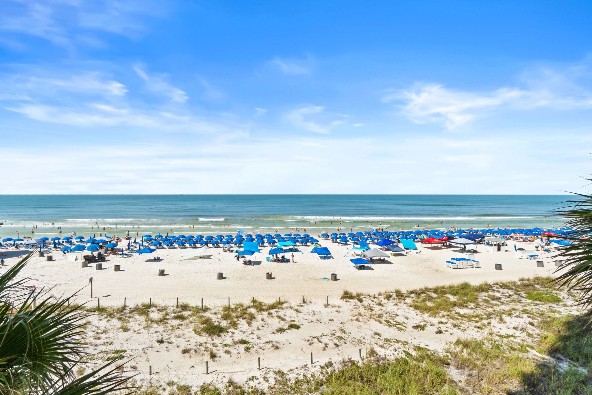 Expansive beach view with white sand and vibrant blue umbrellas