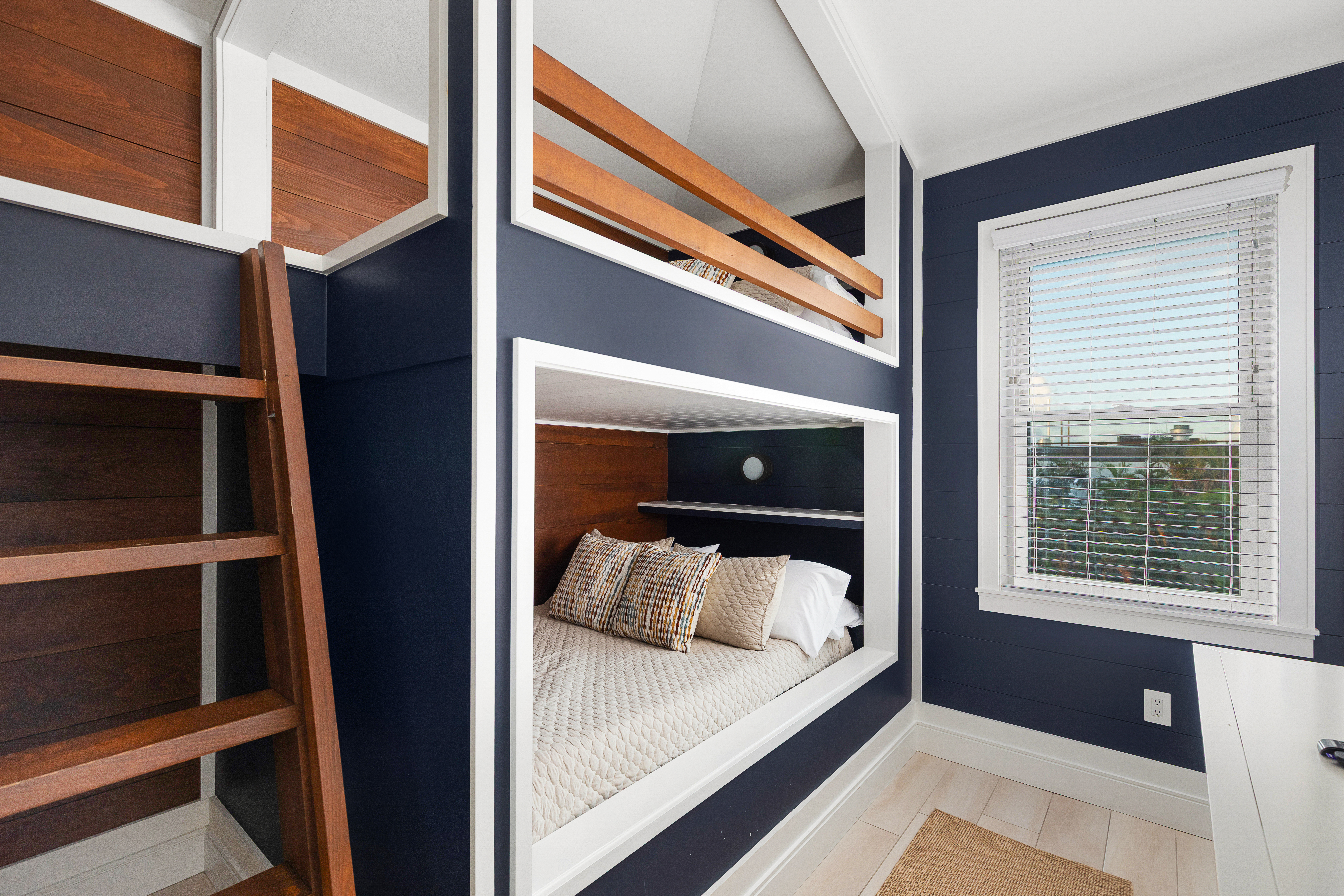 Bunk room with two full-size built-ins, Roku TV and coastal detailing