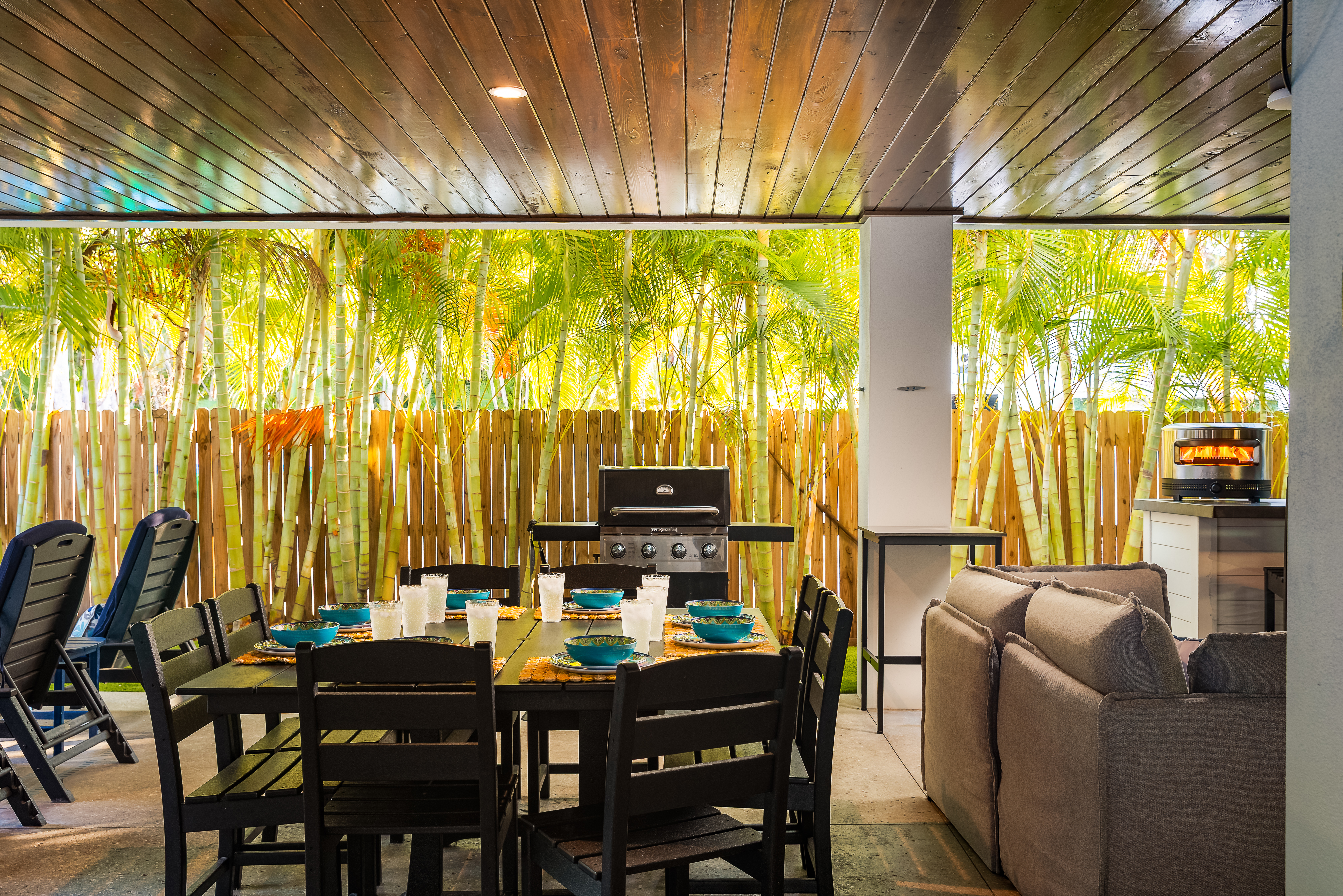 Covered outdoor dining and lounge with seating for eight, grill and pizza oven