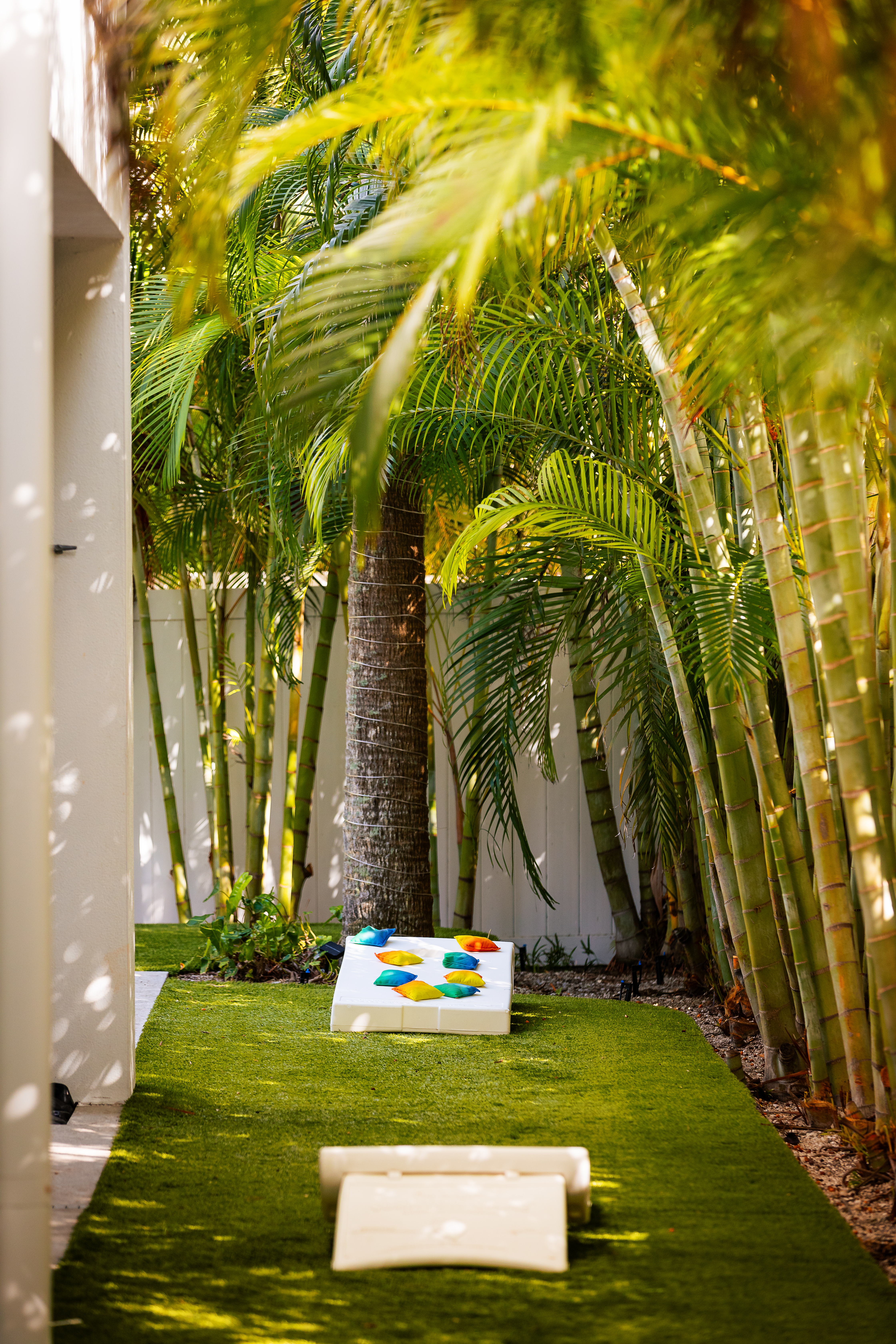 Cornhole set on designer turf surrounded by palms
