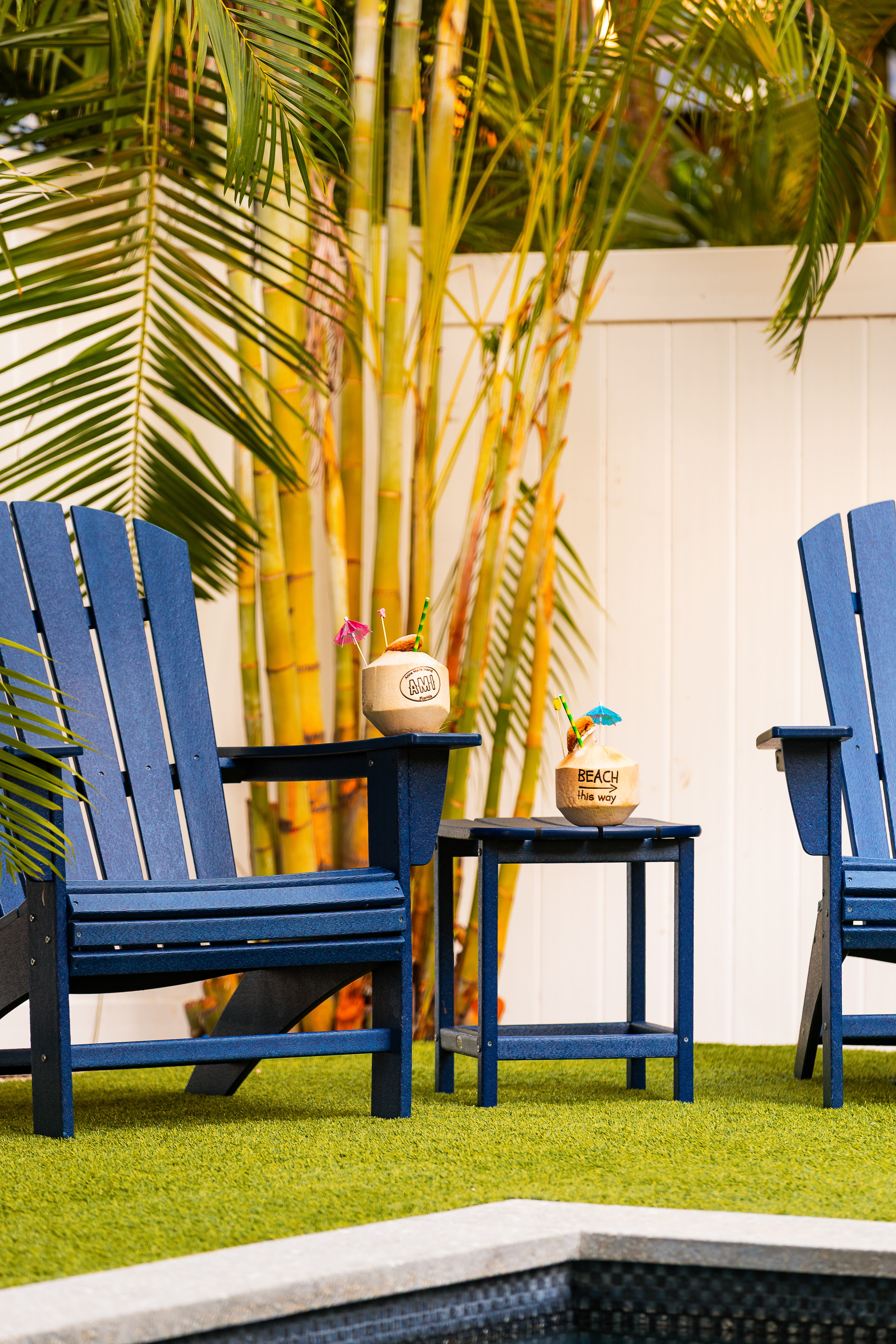 Poolside Adirondack chairs under the palms