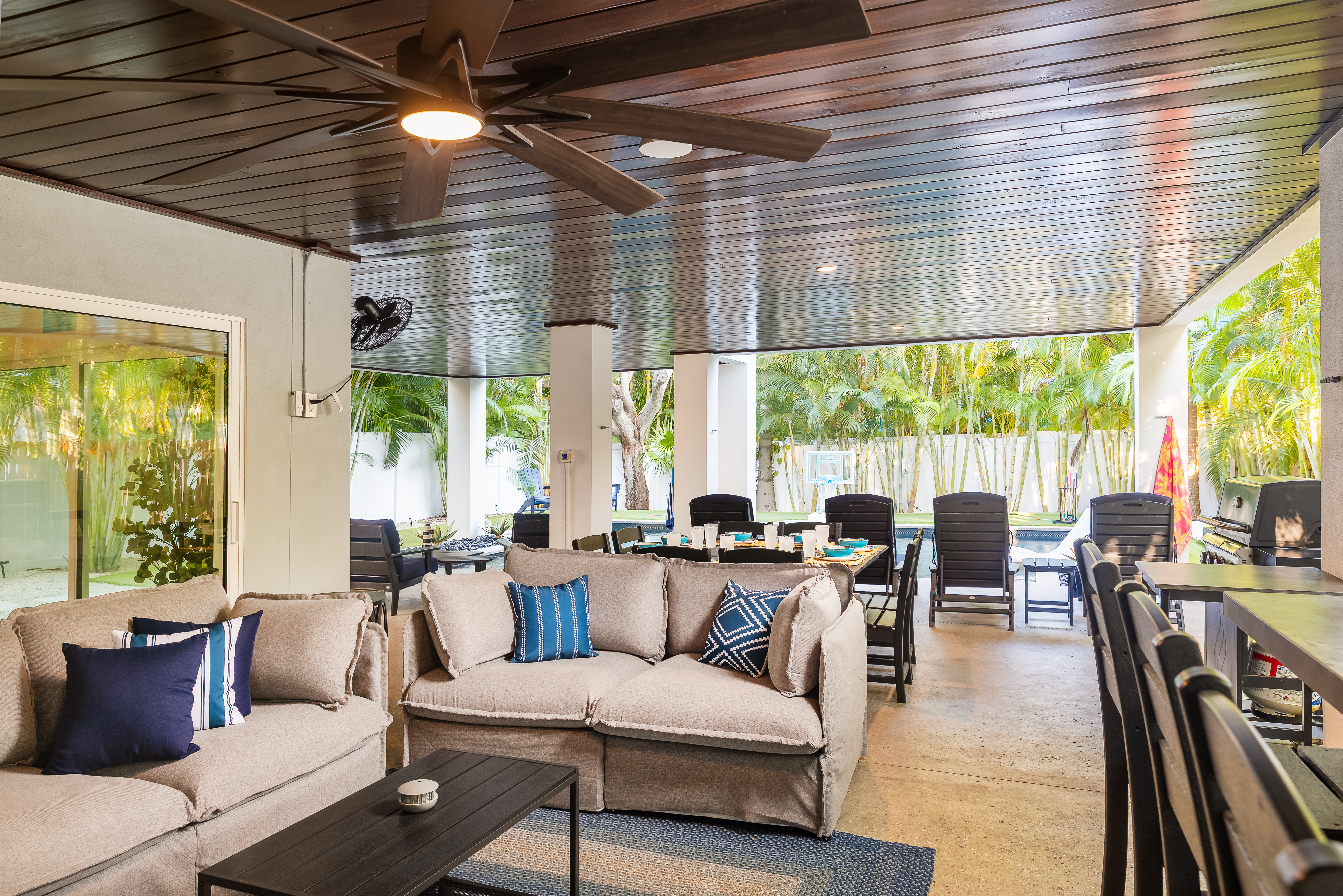 Covered poolside patio with lounge seating and tropical views