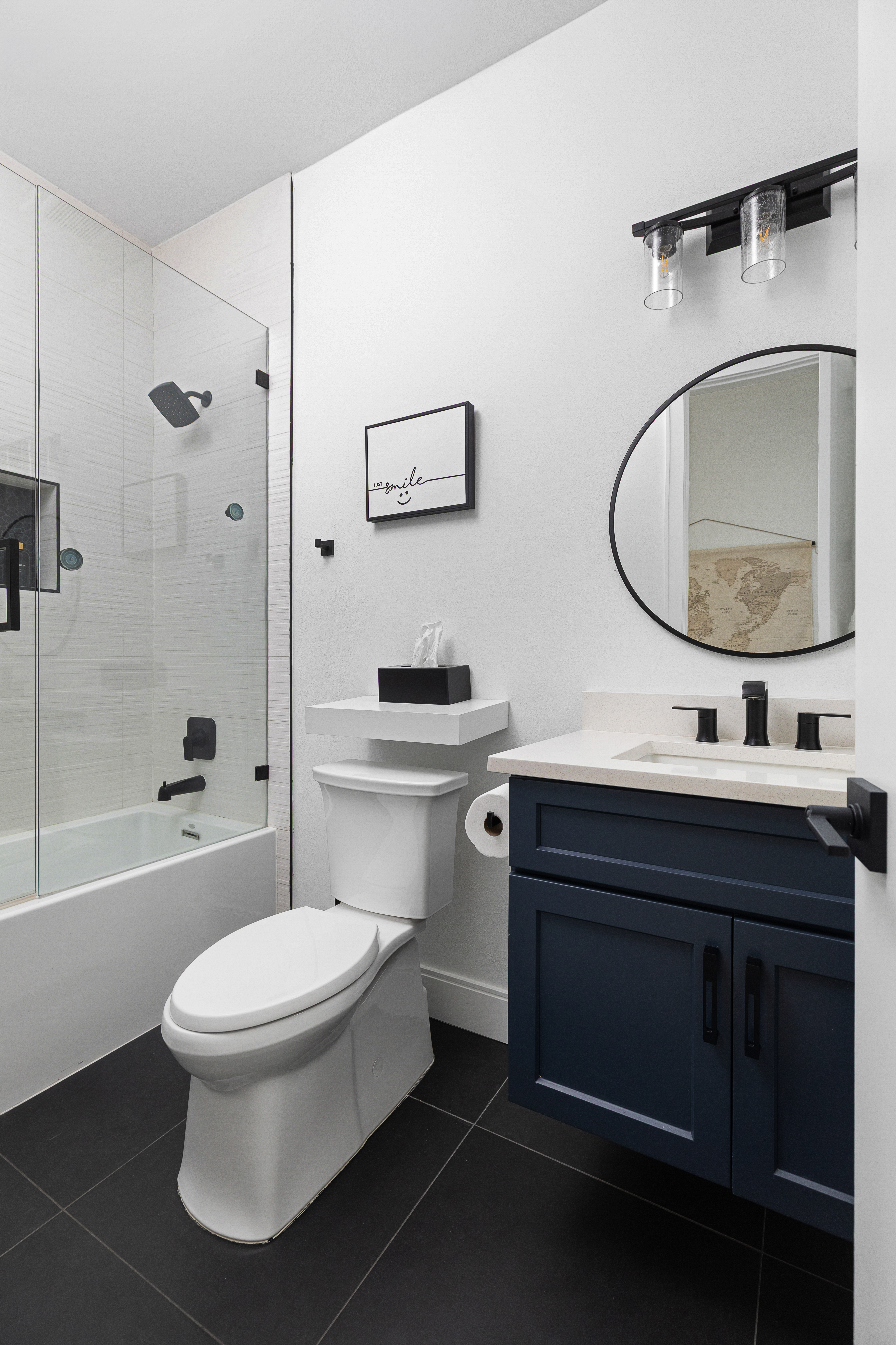 Modern bath with glass shower and navy vanity