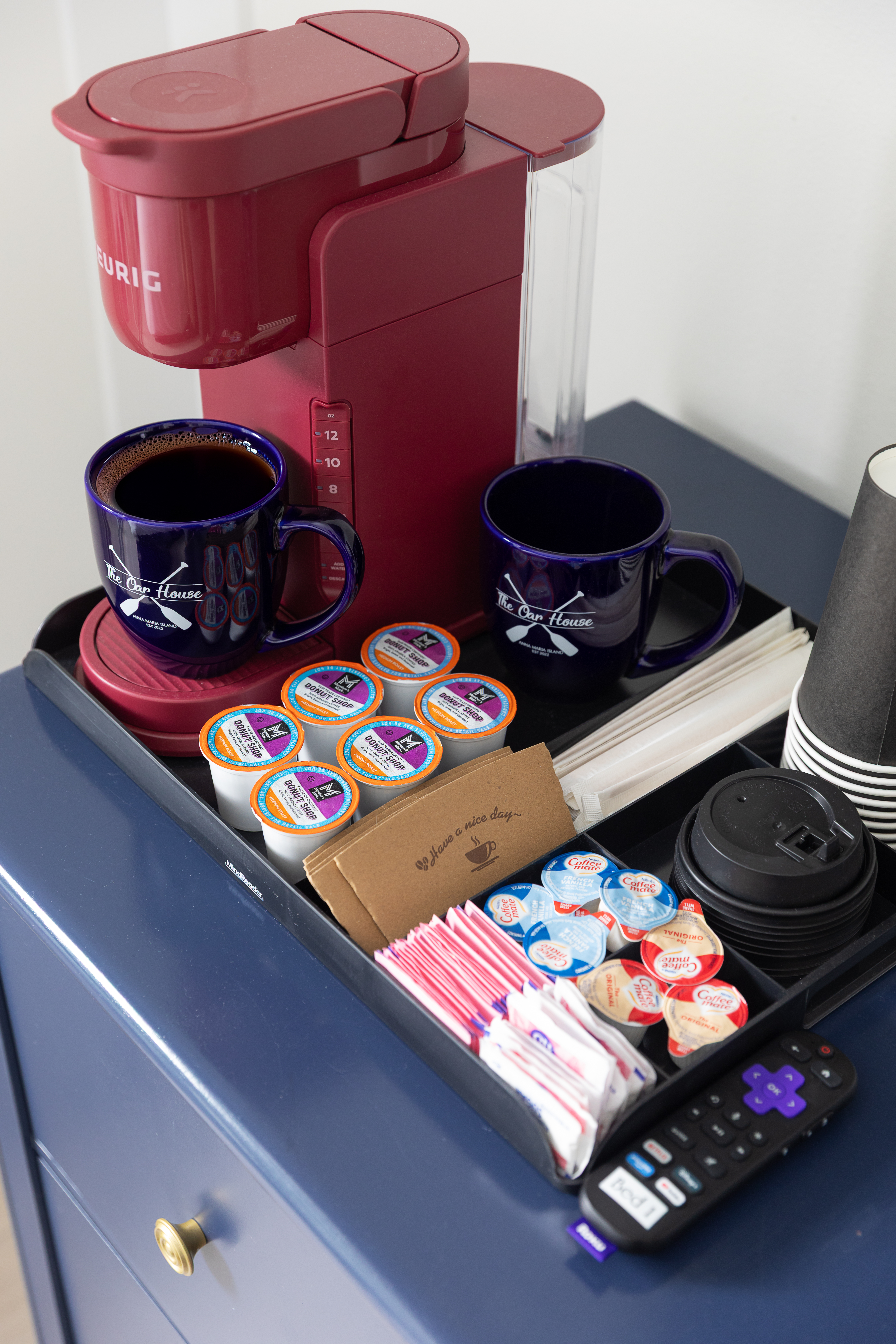 In-room Keurig setup with pods, creamers and mugs