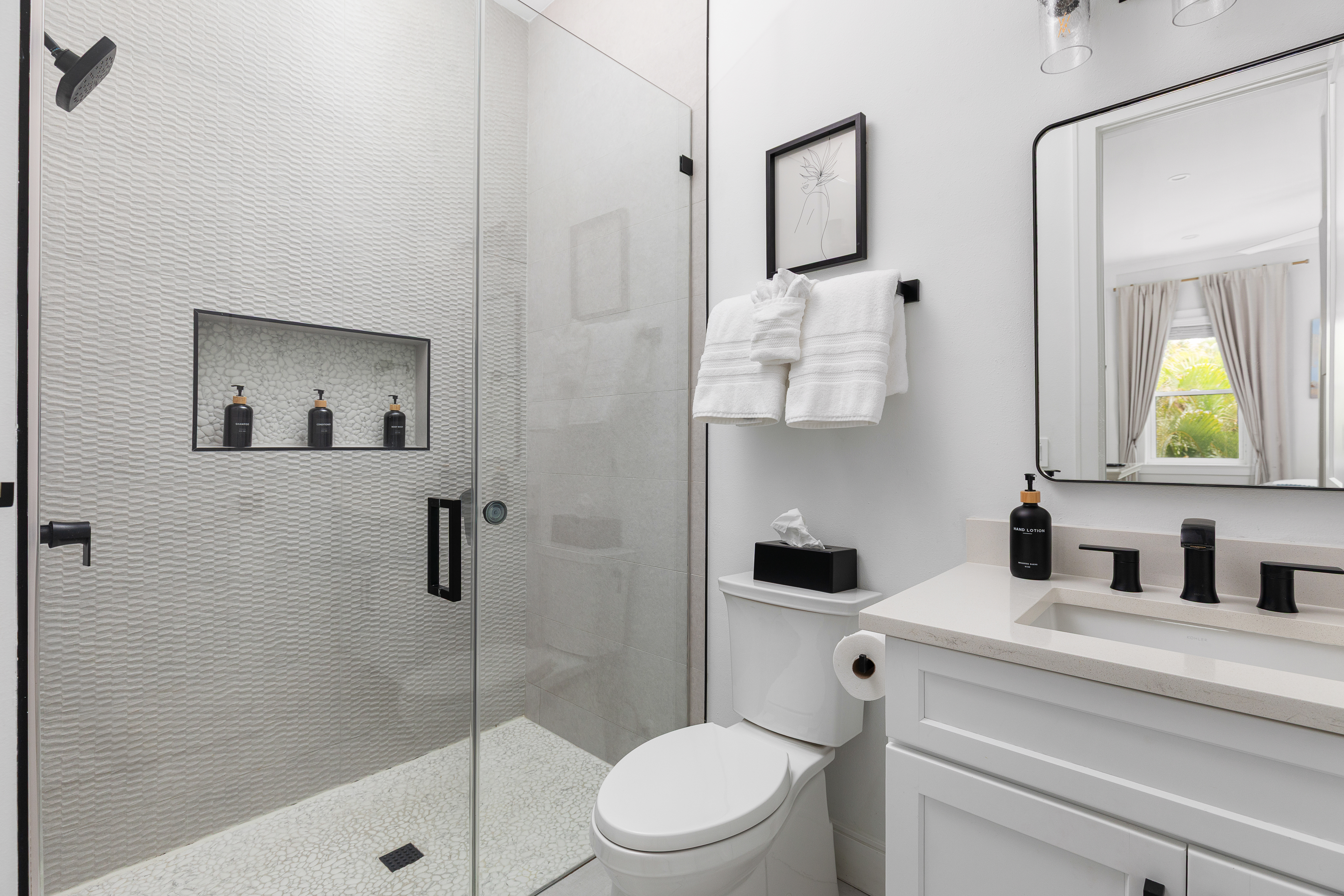 En-suite bath with glass walk-in shower and stocked amenities