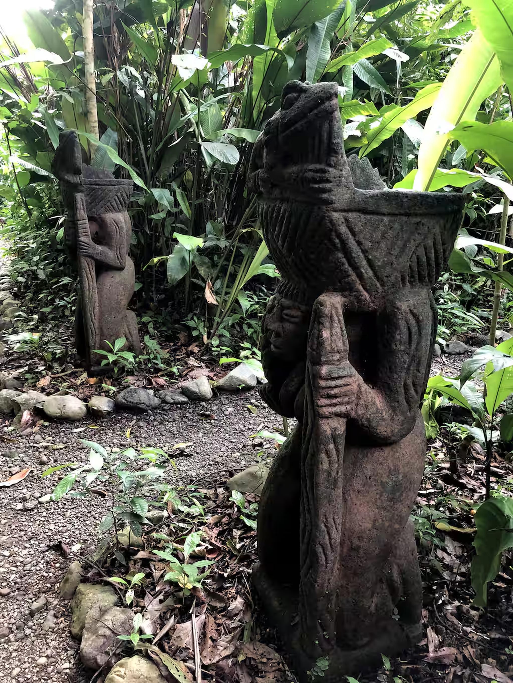 Lush tropical garden path with striking carved stone statues