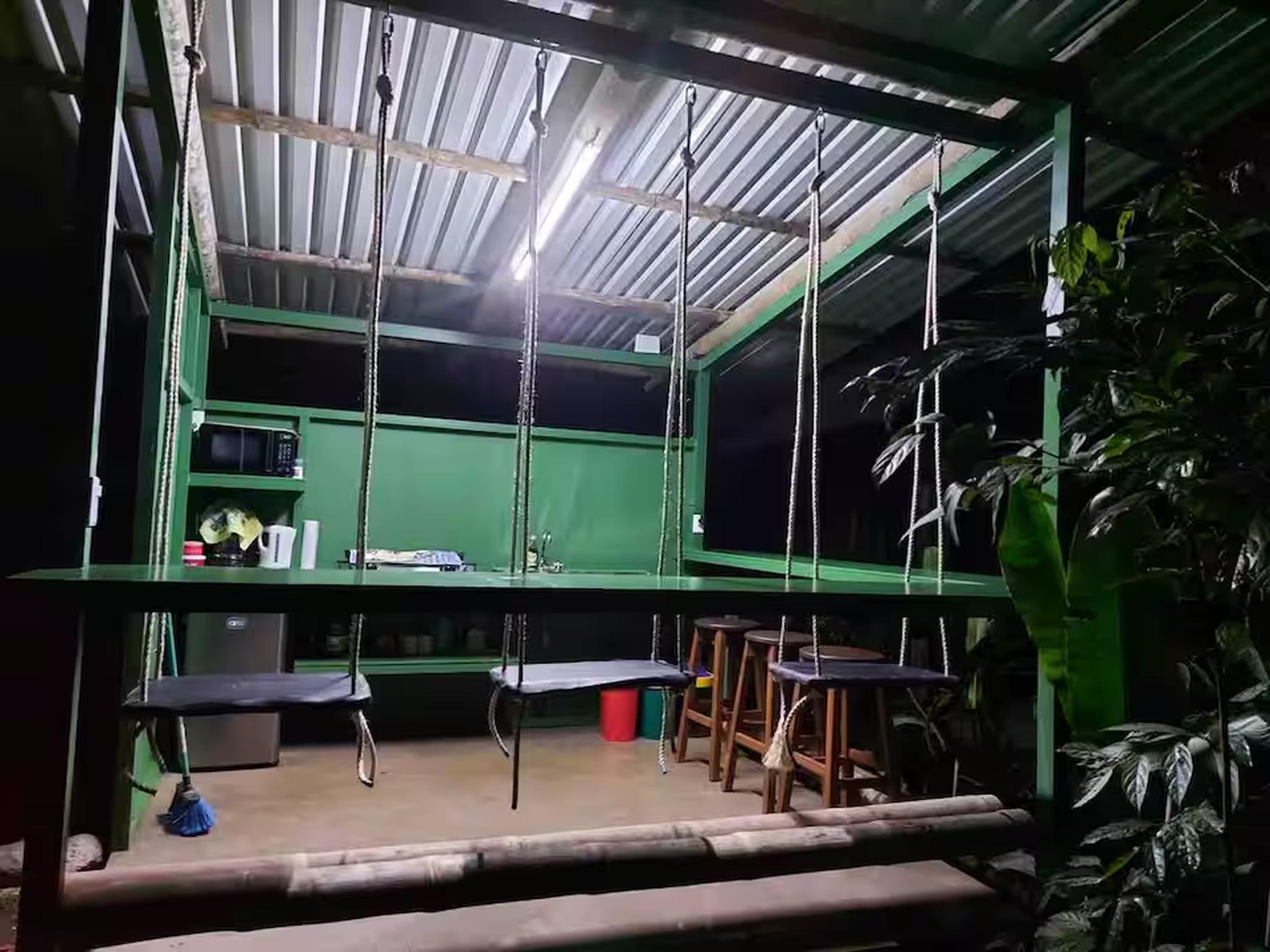 Unique open-air swing dining area with kitchenette and tropical ambiance