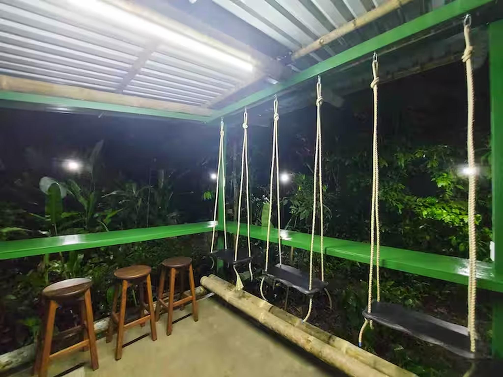 Covered patio with swing seats and lush jungle views for relaxing evenings