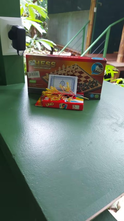 Outdoor game nook with chess, cards, and UNO in a lush tropical setting