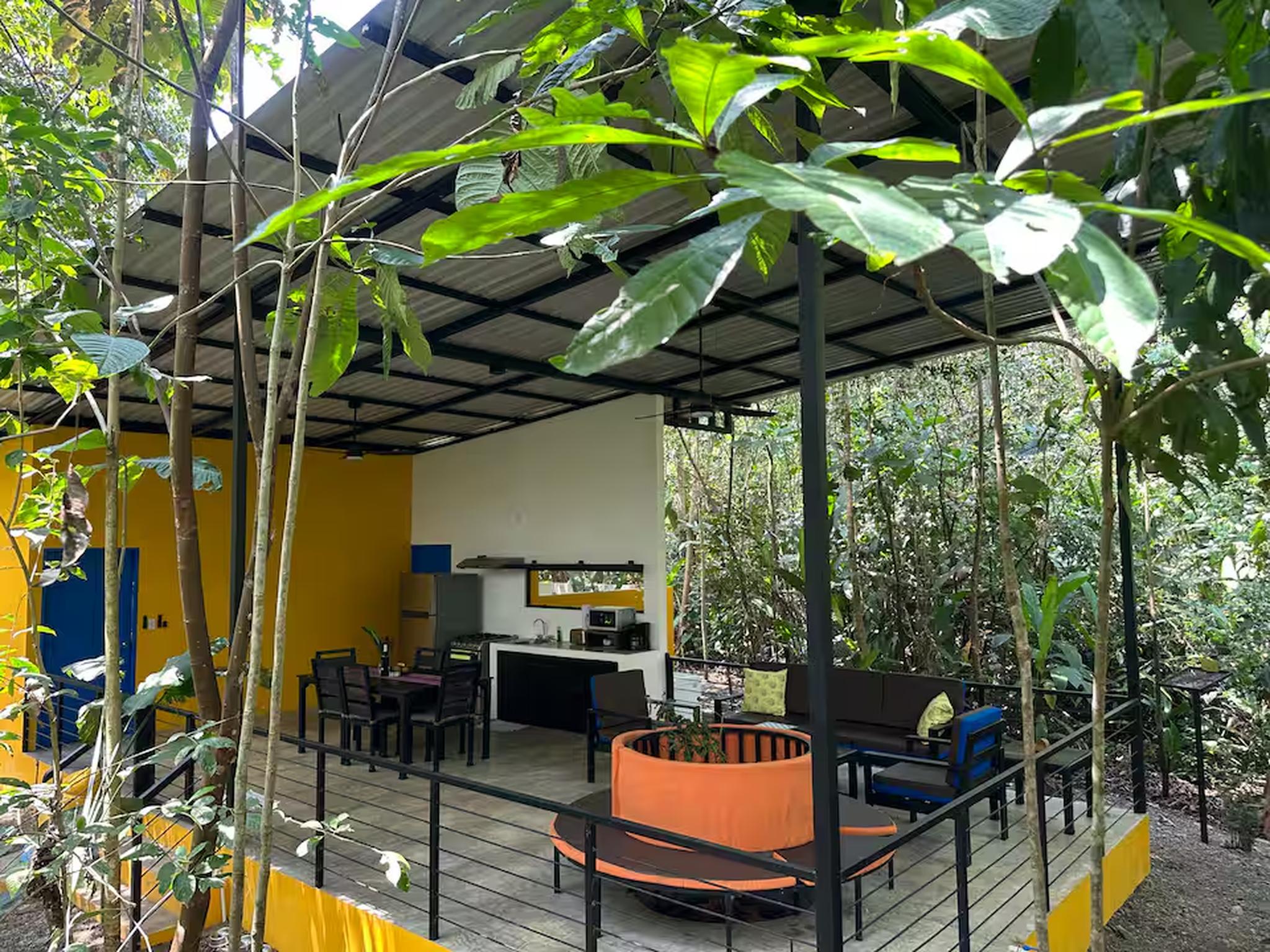 Covered jungle terrace with outdoor dining, seating, and kitchenette
