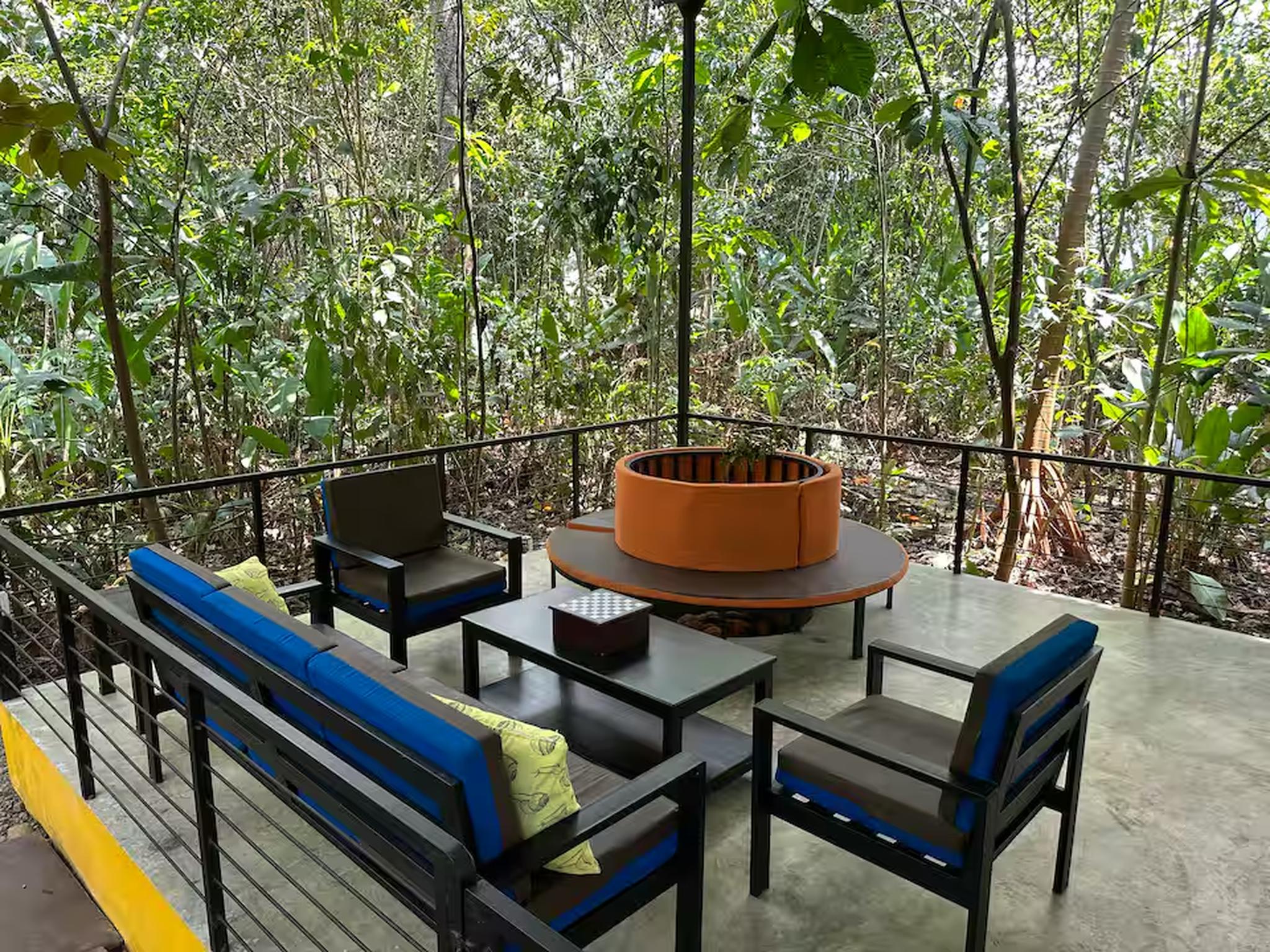 Private jungle patio with modern seating and a cozy fire pit
