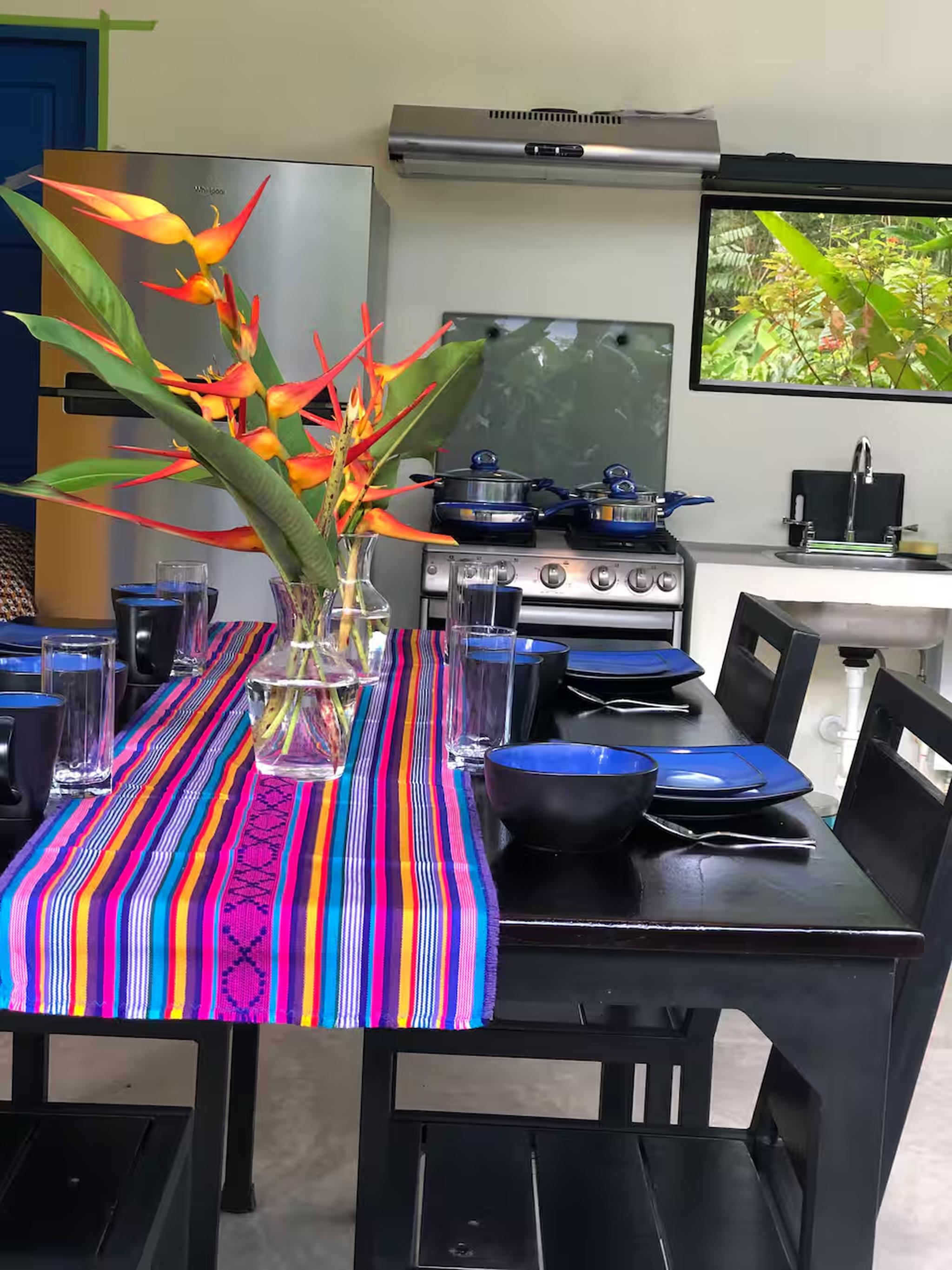 Colorful tropical dining space with modern kitchen and garden views