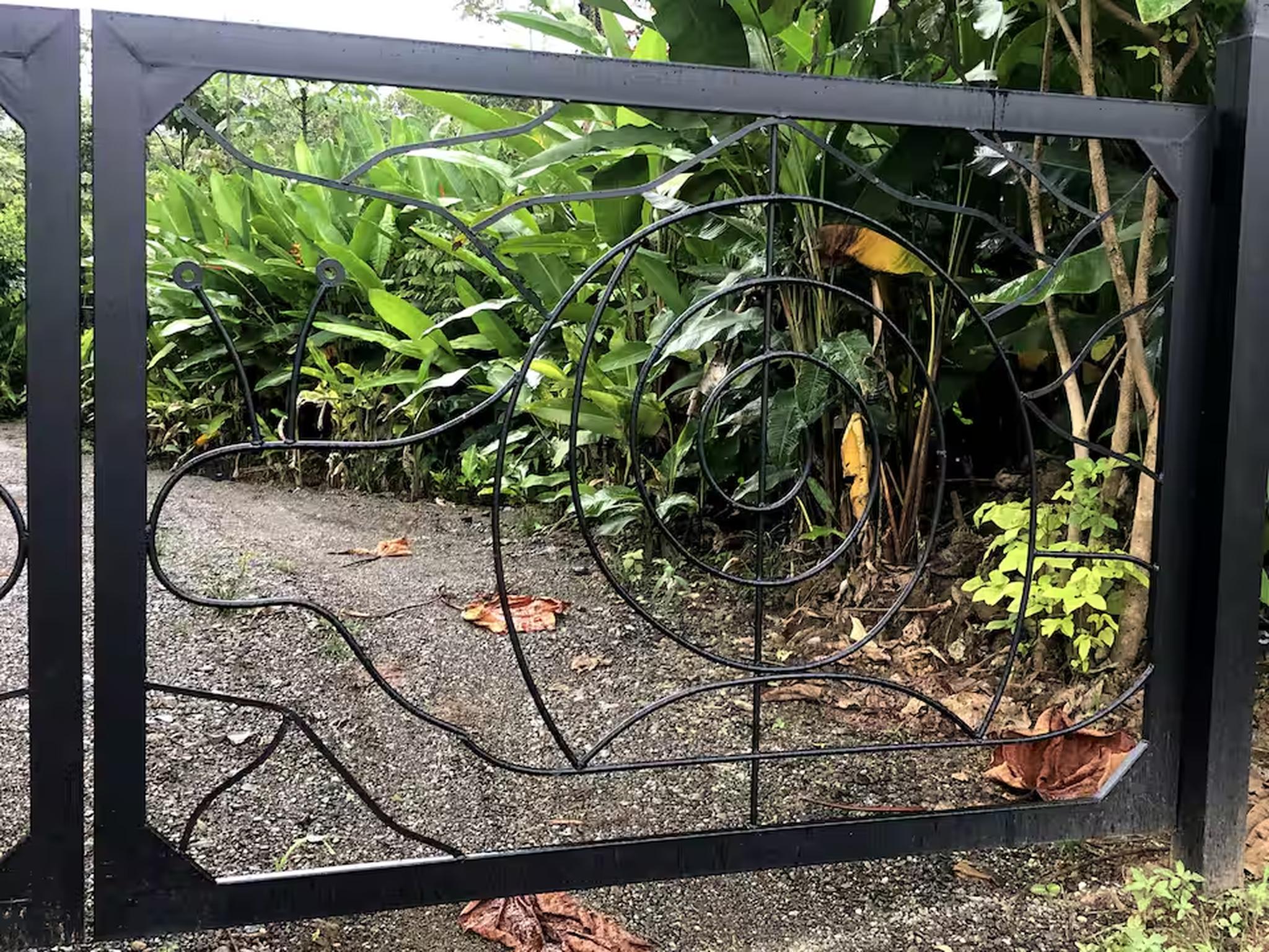 Private tropical garden entry with charming decorative gate