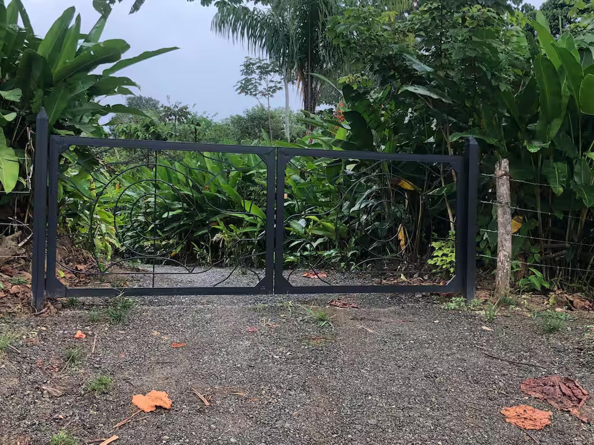 Private tropical gated entry surrounded by lush greenery