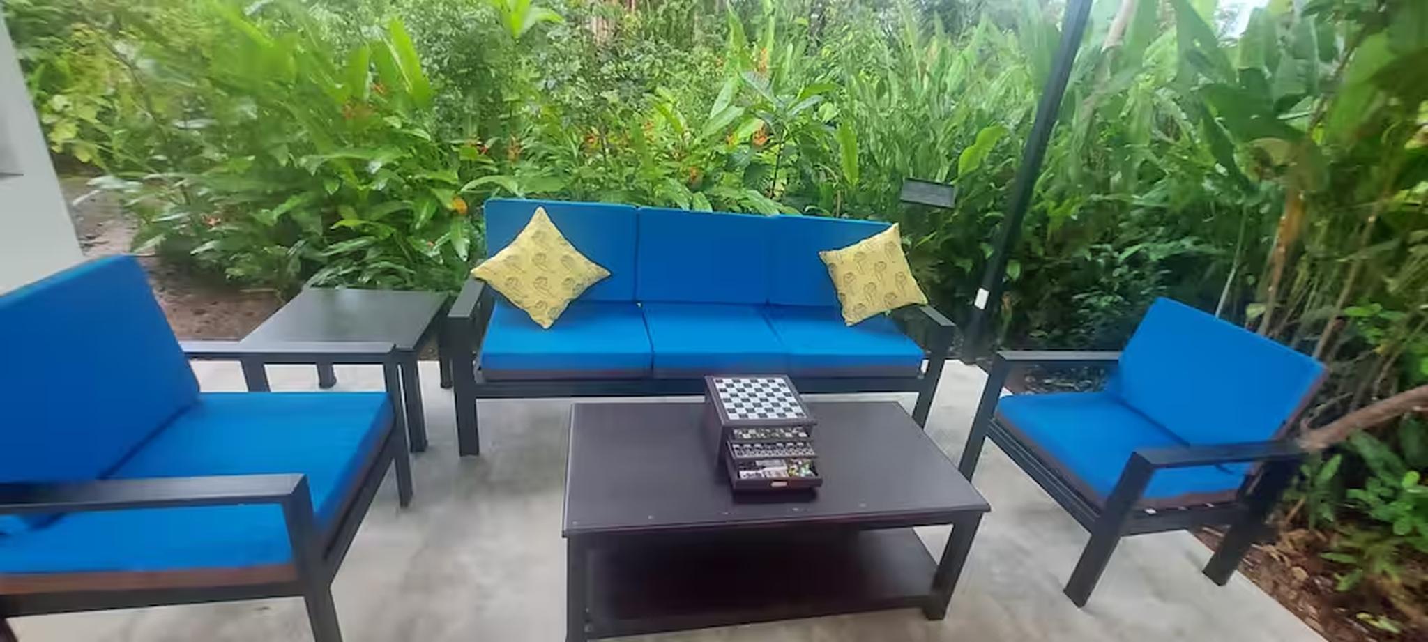 Private tropical patio with cozy seating and lush garden views