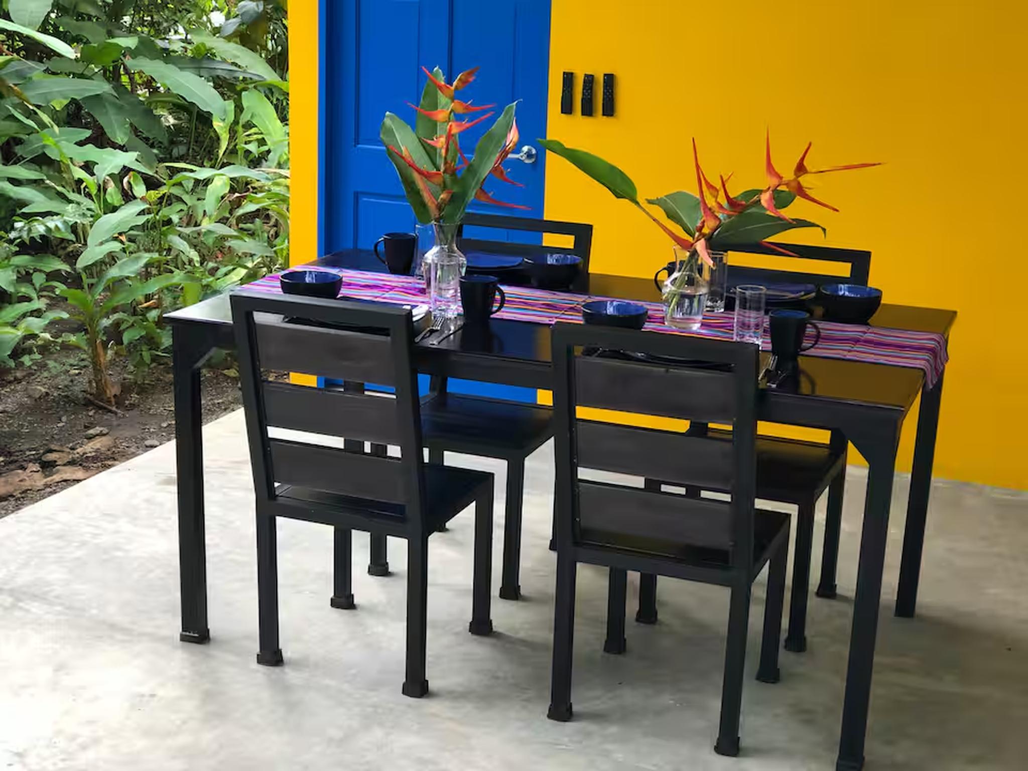 Vibrant tropical patio dining with bold colors and lush garden views