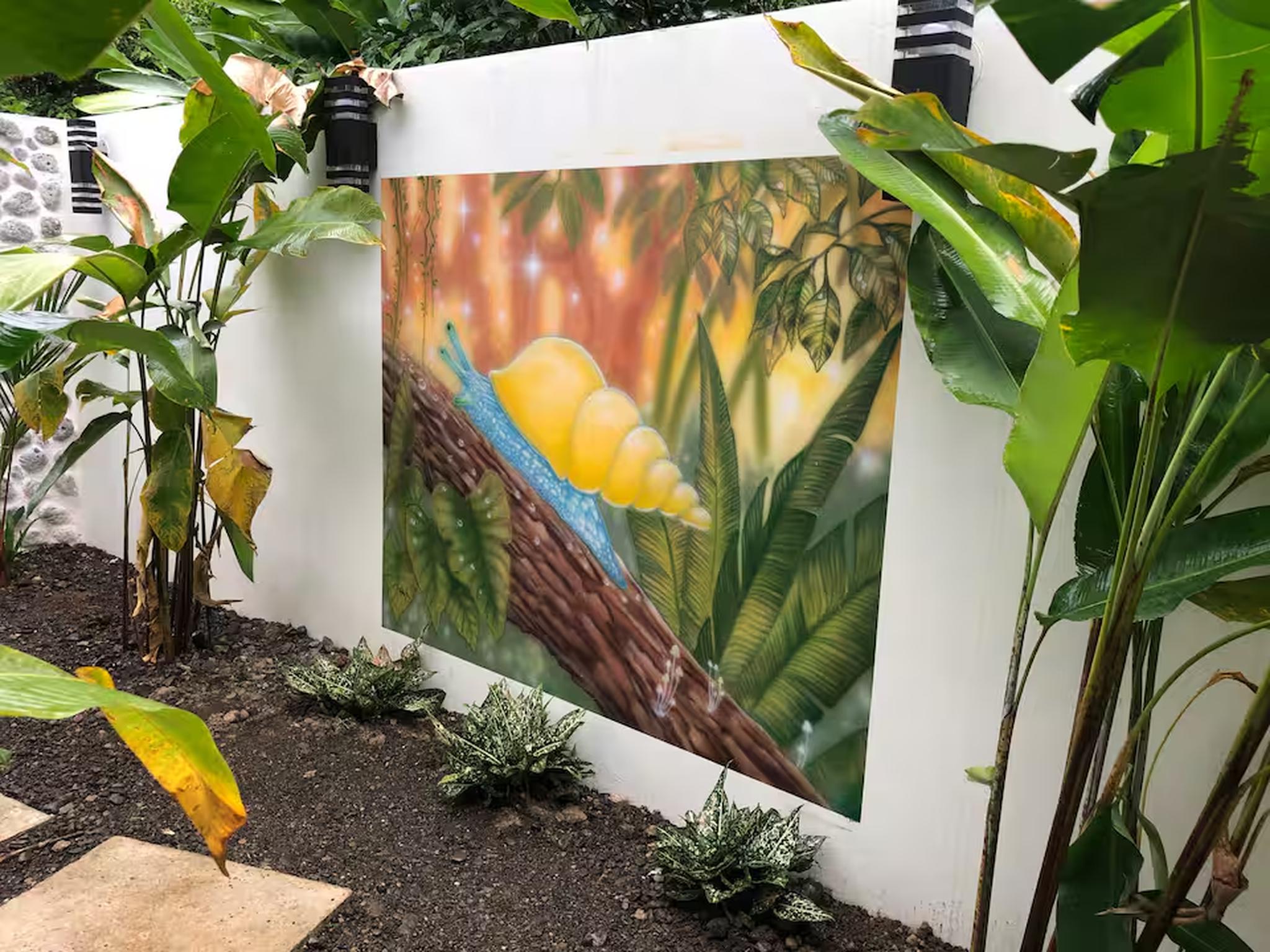Lush tropical garden with vibrant mural and serene outdoor ambiance