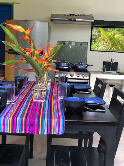 Colorful tropical dining space with modern kitchen and garden views