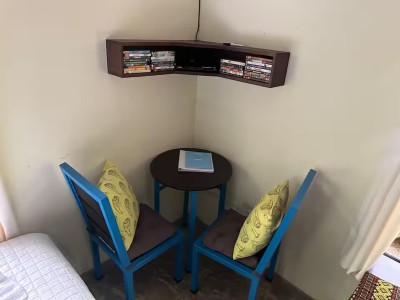 Cozy reading and coffee nook with bright seating and DVD shelf