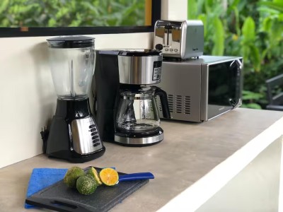 Well-equipped kitchen counter with coffee maker, blender, and tropical views