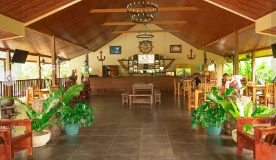 Open-air tropical lounge with vaulted wood ceilings and a welcoming bar