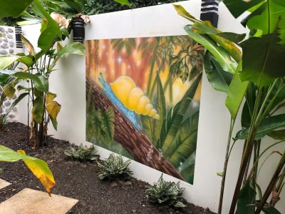 Lush tropical garden with vibrant mural and serene outdoor ambiance