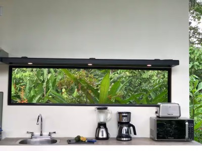 Bright tropical kitchenette with jungle-view window and coffee setup
