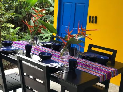 Colorful tropical outdoor dining space surrounded by lush greenery
