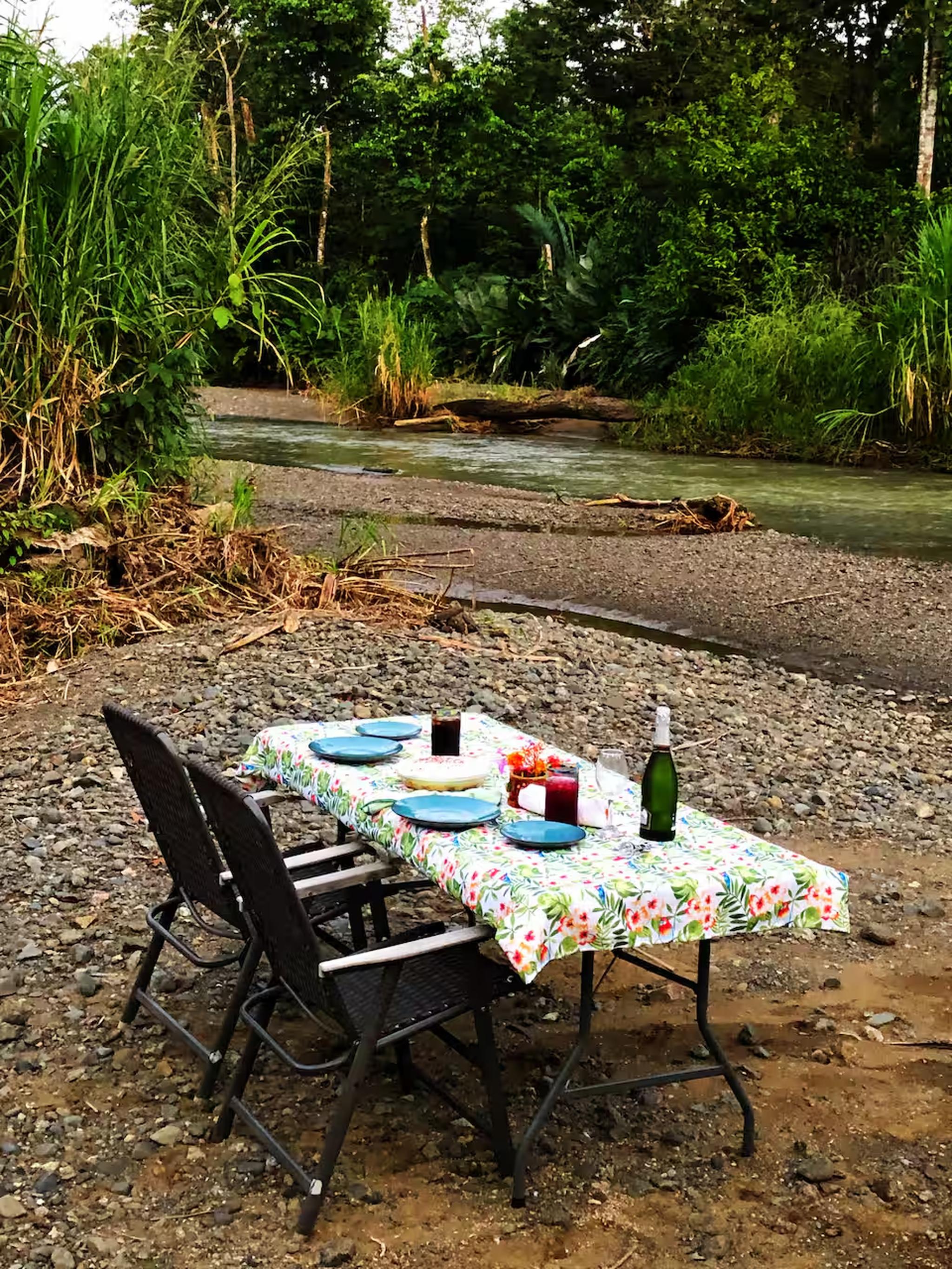 Private creekside dining surrounded by lush tropical greenery