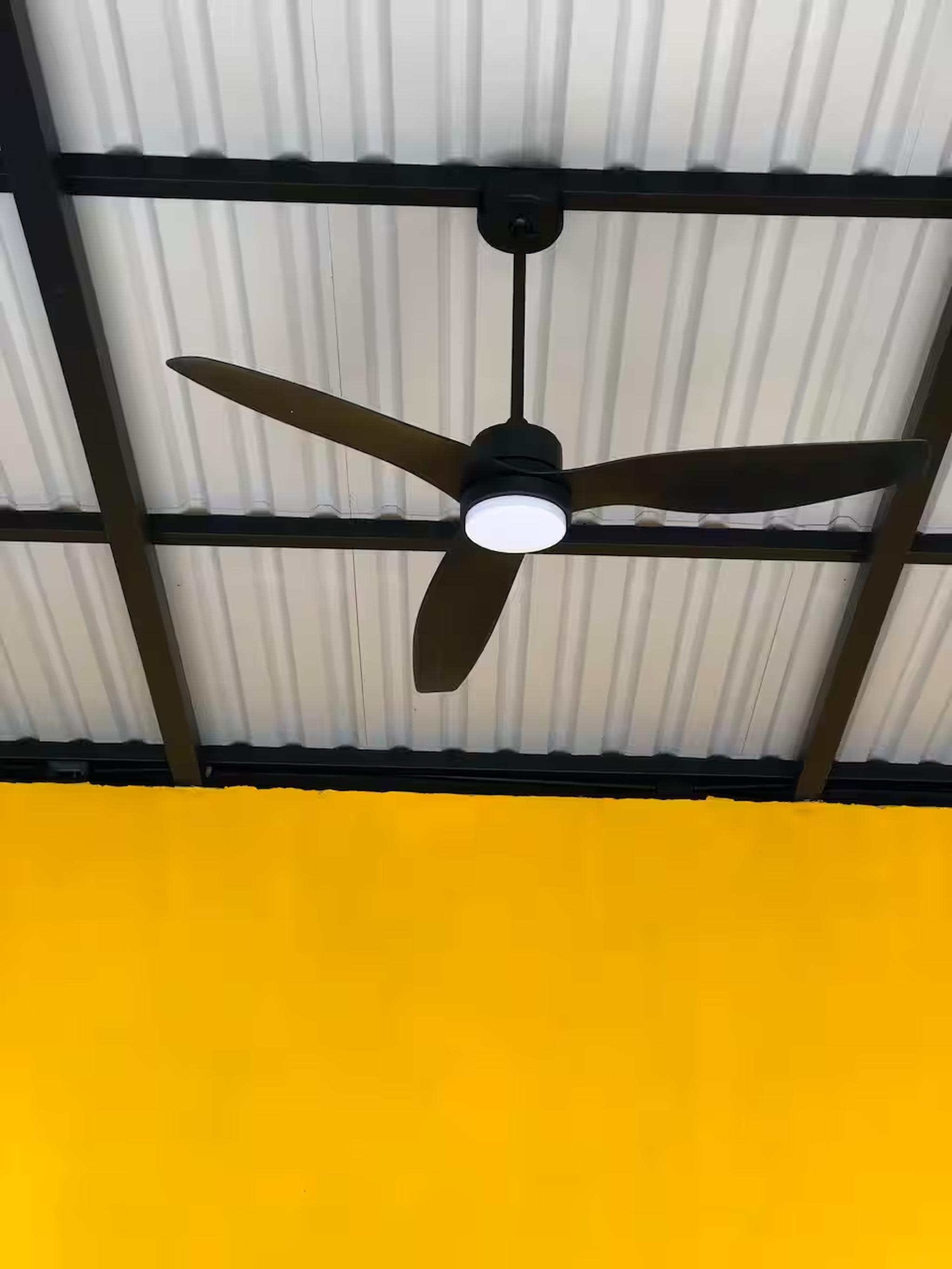 Modern ceiling fan with light in a bright, covered outdoor space