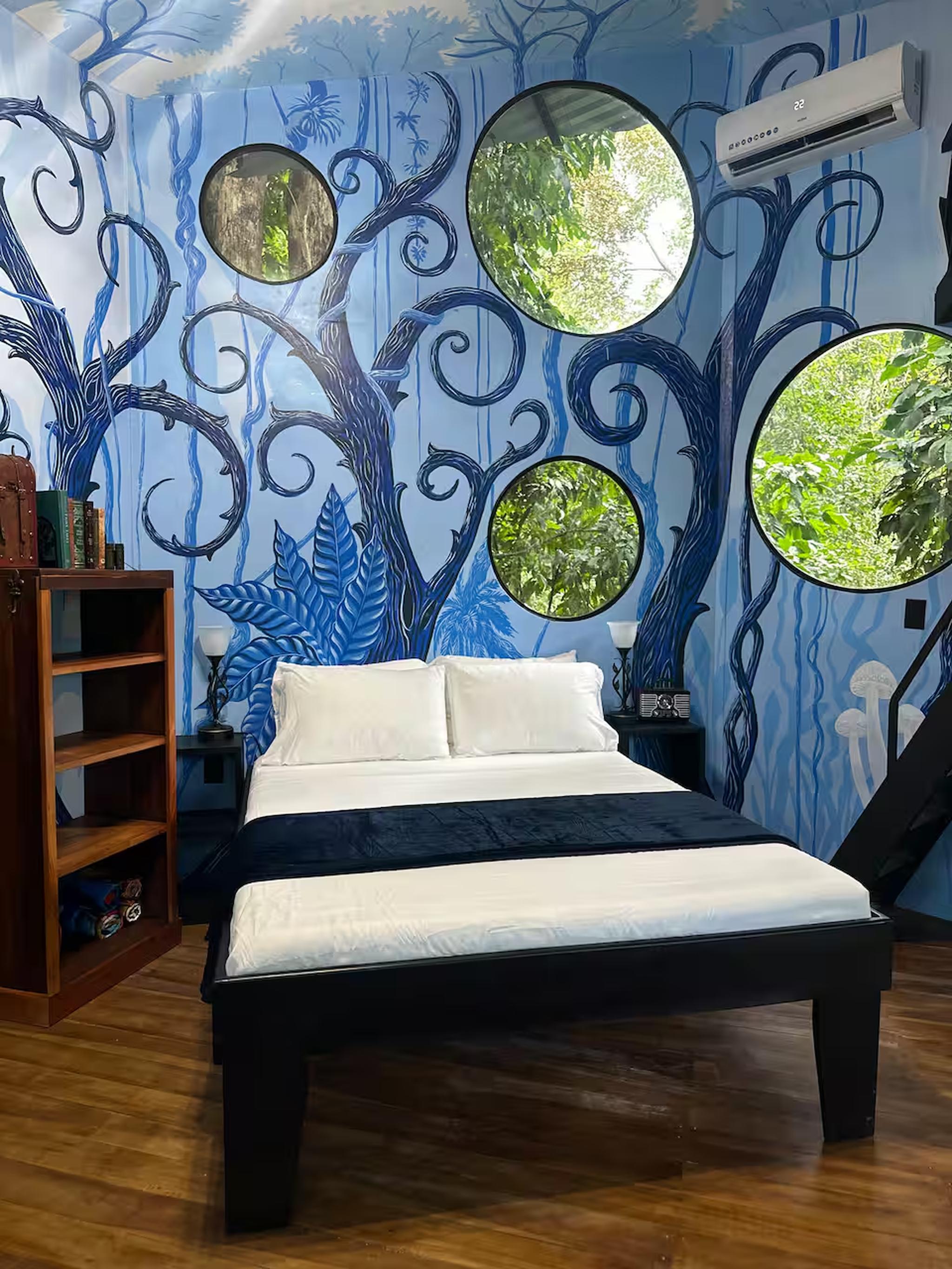 Whimsical mural bedroom with round windows and lush jungle views
