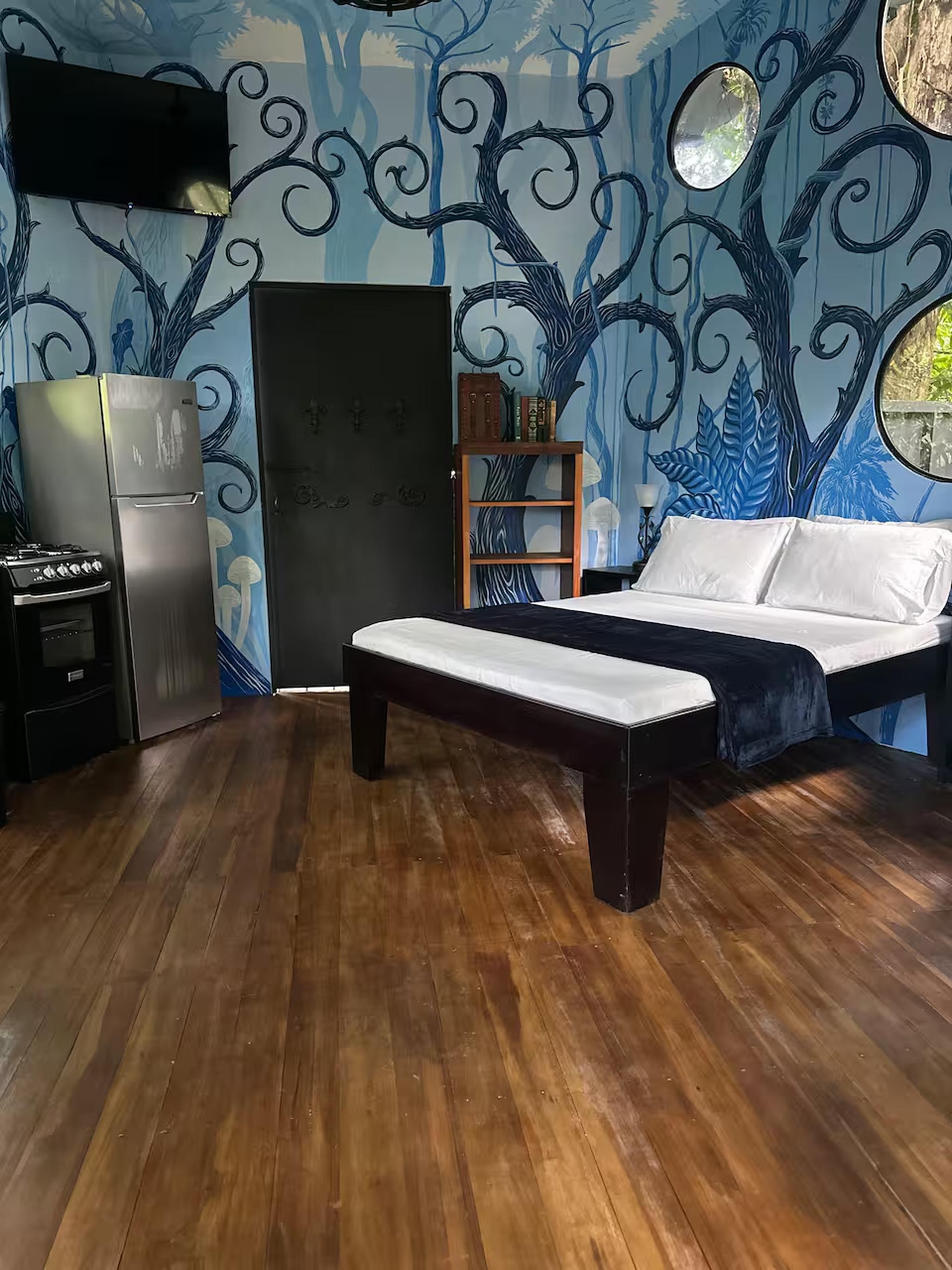 Artistic studio retreat with bold mural, kitchenette, and cozy bed