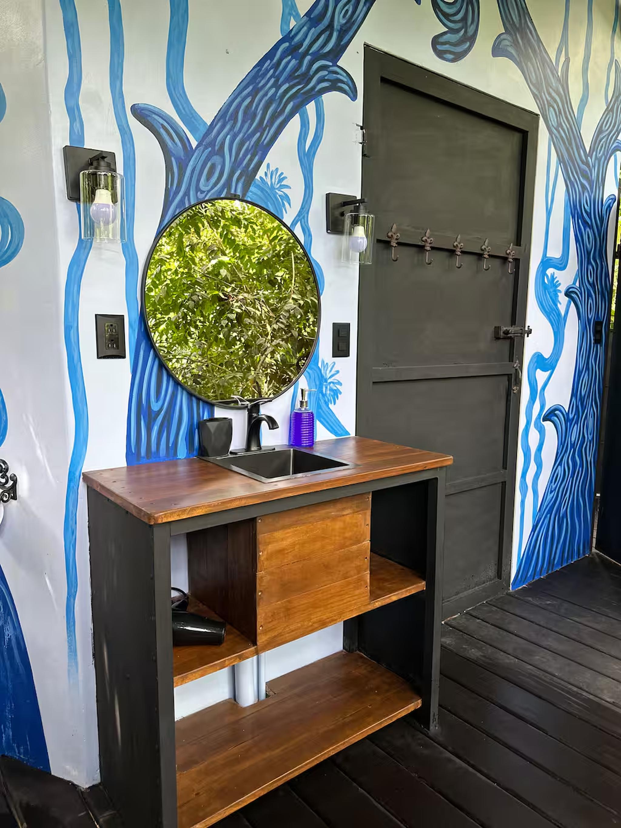 Artful vanity nook with bold mural, wood finishes, and modern mirror