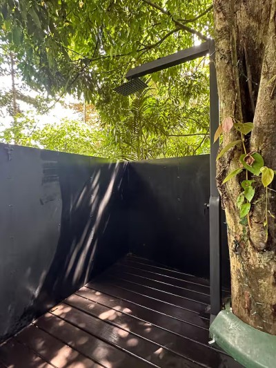 Private open-air rainforest shower with peaceful tropical surroundings