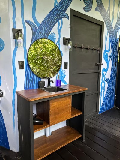 Artful vanity nook with bold mural, wood finishes, and modern mirror
