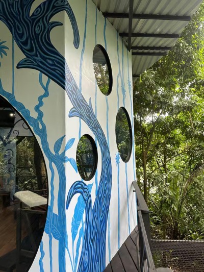 Artful jungle hideaway with porthole windows and tropical views