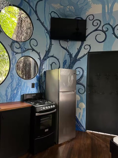 Artful kitchen with forest mural, natural light, and full-size appliances