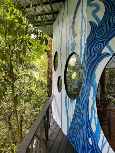 Treehouse-style balcony with bold mural and lush jungle views