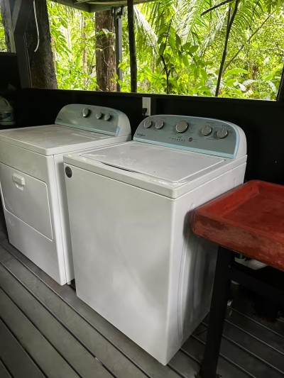 Full-size washer and dryer on a covered deck with tropical views