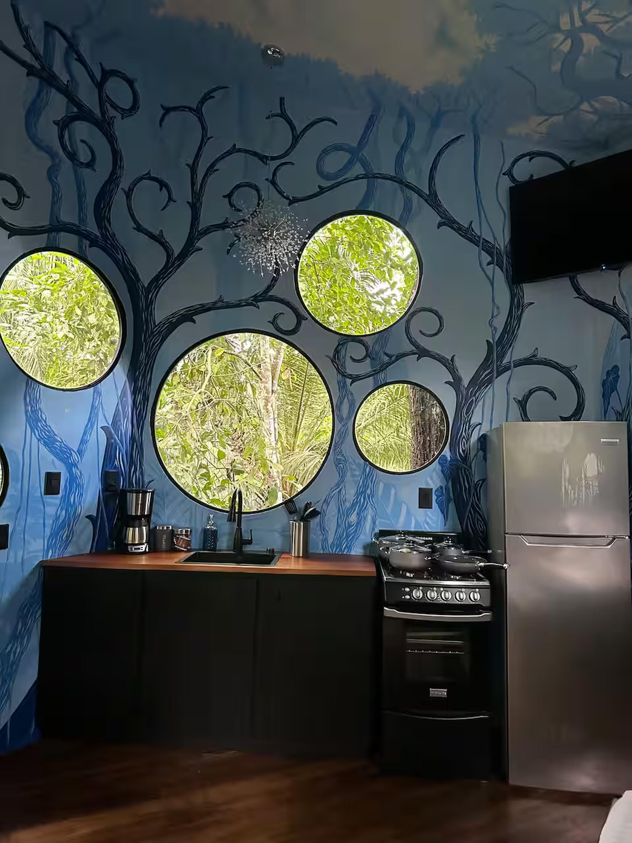 Artistic kitchen with round jungle-view windows and a magical, nature-inspired design