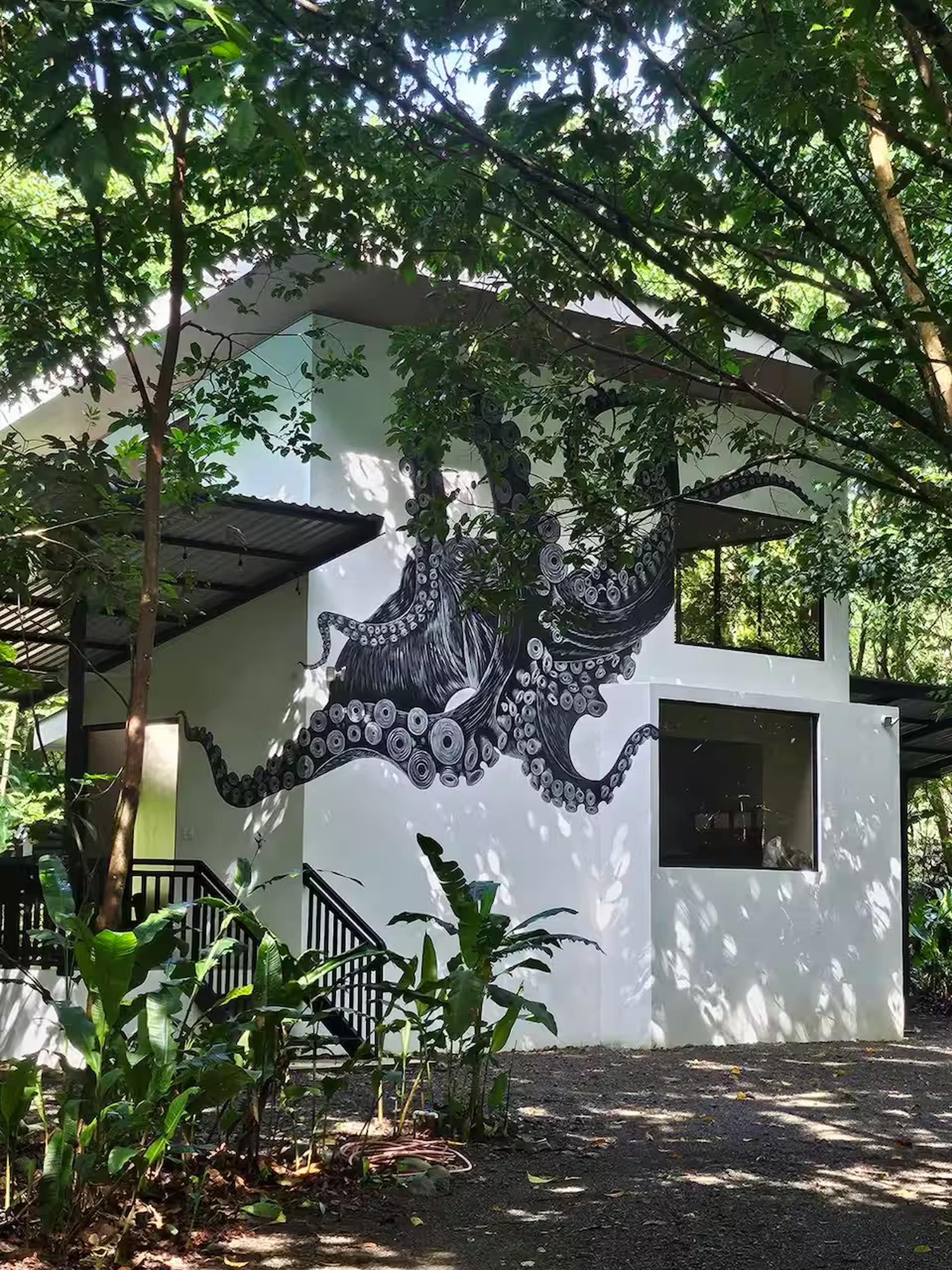 Art-filled jungle cabin with bold mural and serene tropical surroundings