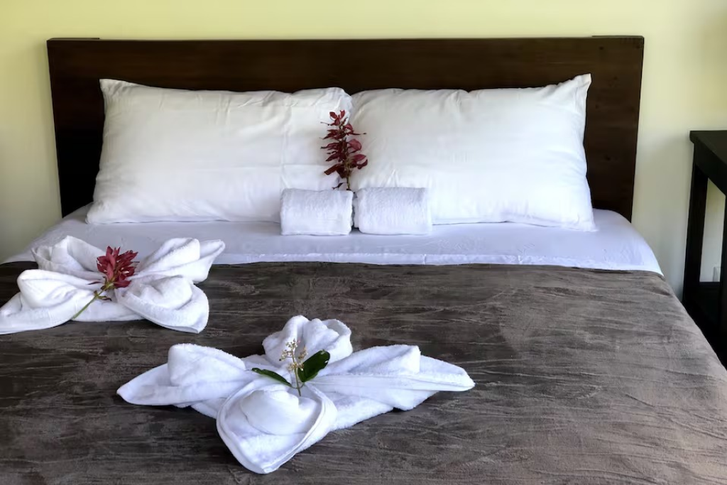 Cozy bed with crisp linens and charming floral towel decor