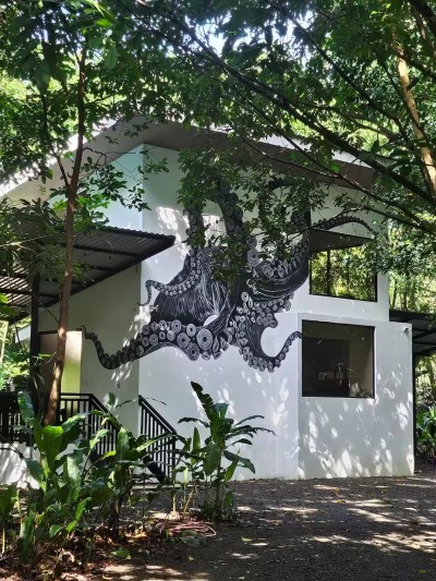 Art-filled jungle cabin with bold mural and serene tropical surroundings
