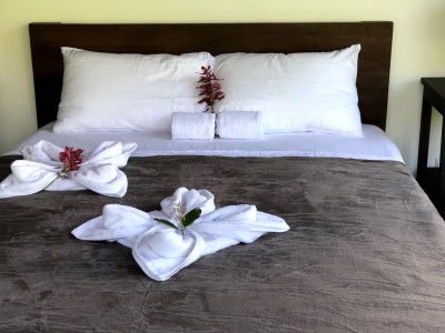 Inviting bed with crisp linens and charming floral towel décor