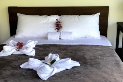 Cozy bed with crisp linens and charming floral towel decor