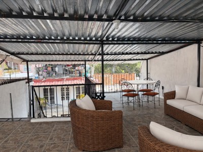 Covered rooftop terrace with cozy seating and outdoor dining area