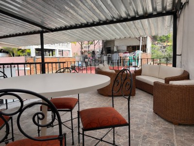 Spacious covered terrace with dining table and cozy wicker lounge seating