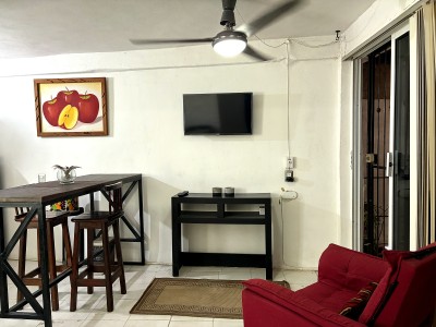 Cozy lounge with TV, bar-style dining, and bright sliding door access