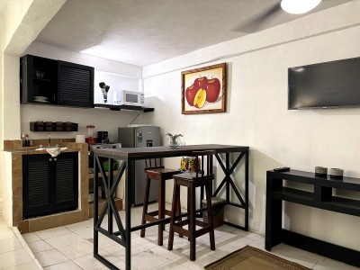Cozy kitchenette with high-top dining table, TV, and coffee station